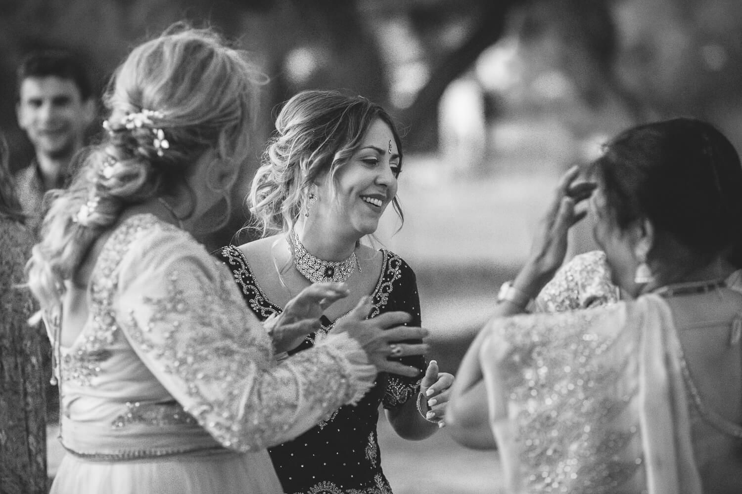 Joyful outdoor dancing at a French-Indian wedding celebration in the Cyclades