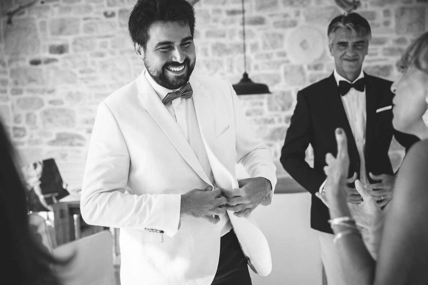 Groom putting on his wedding suit in a luxury Paros villa