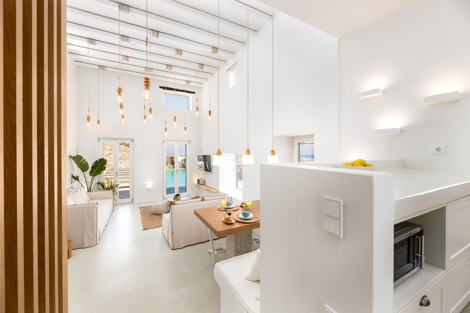 Modern open-plan living space with high ceilings, and ocean view in Golden Beach Paros.