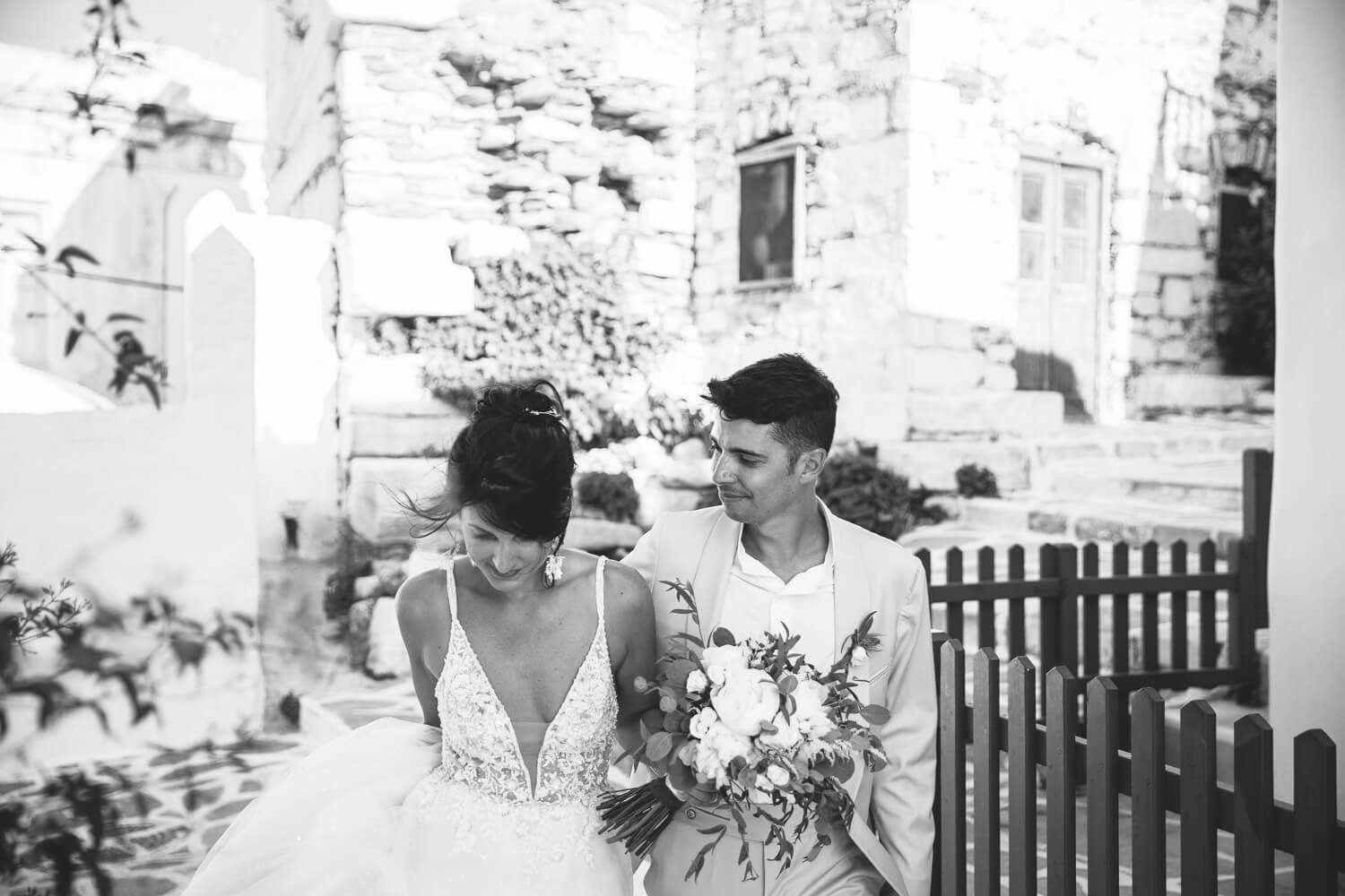 Candid stroll of the newlyweds holding hands in the old town of Parikia