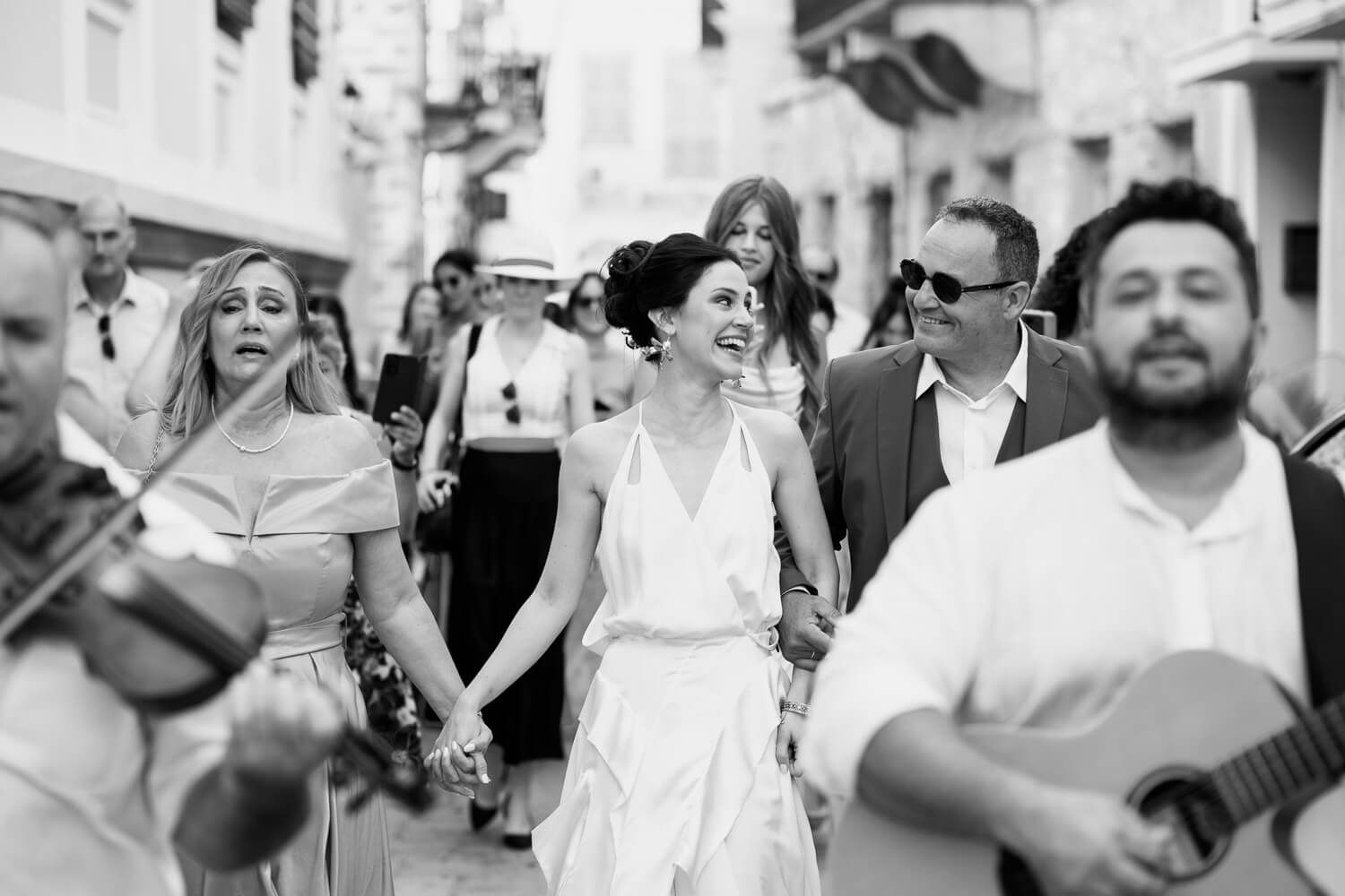 Bride escorted by family members to her wedding ceremony at the Townhall odf Syros island.