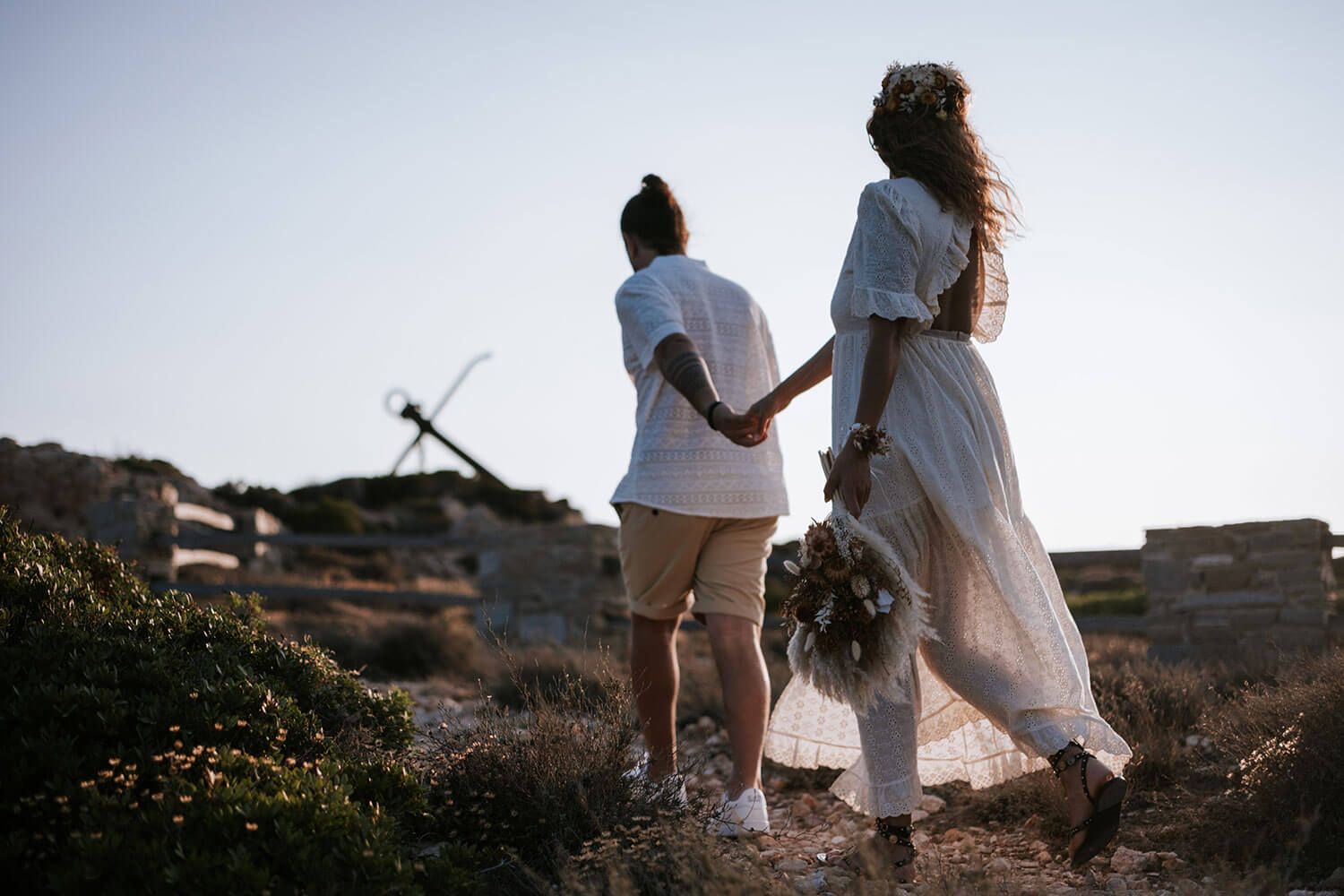 Meli and Rady exploring the wild Cycladic landscape during their engagement session
