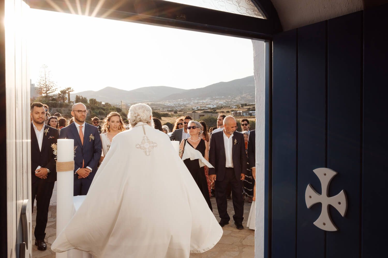 Wide shot of the picturesque Pyrgaki chapel surrounded by guests
