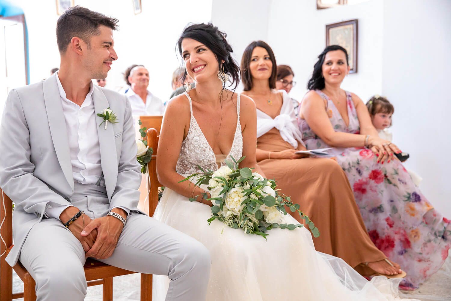 Newlyweds smiling at each other under the stunning architecture of St. Antony's