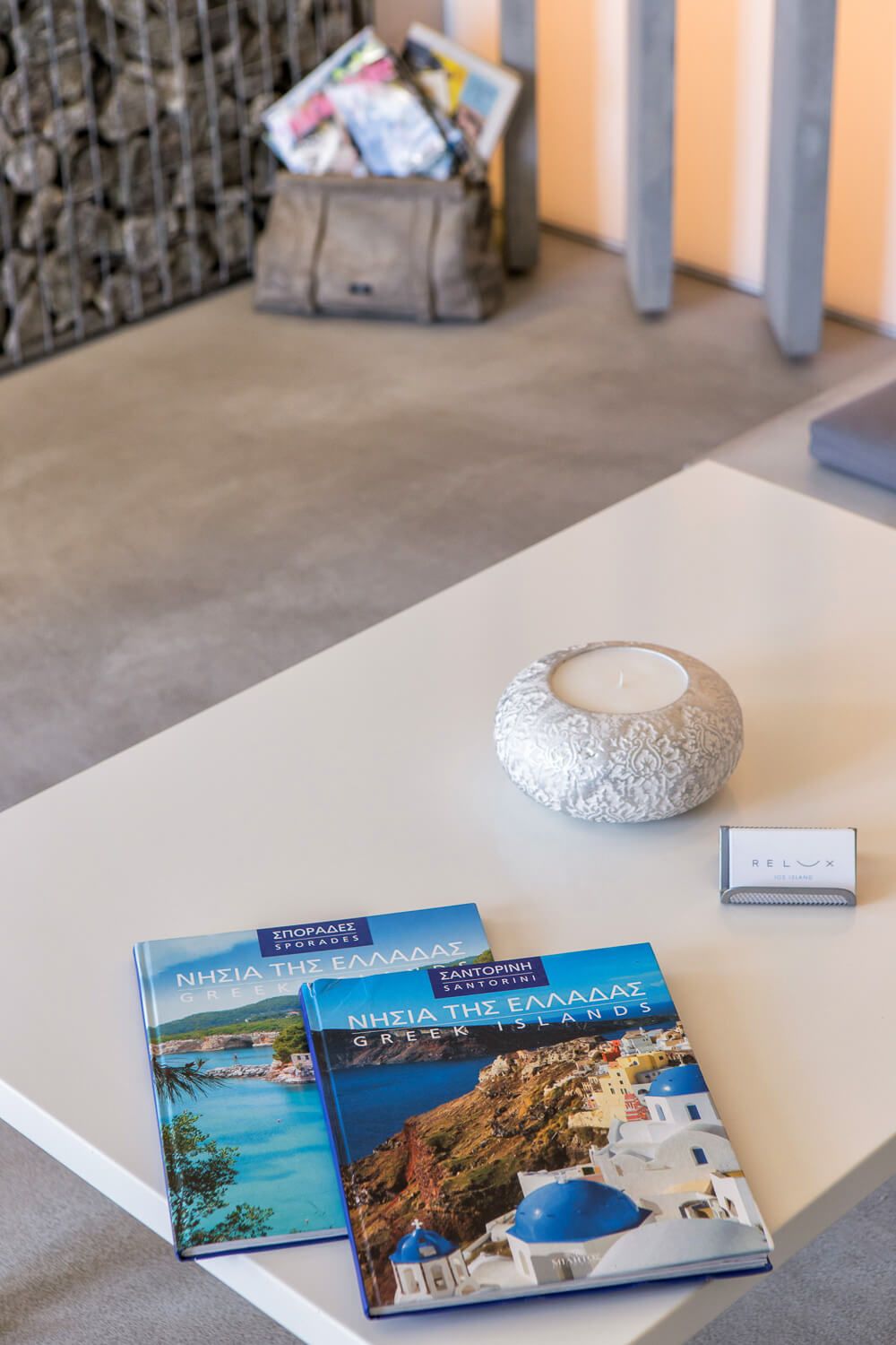 A series of travel photo books about Greece with blue domes and coastal scenes displayed on a light surface.