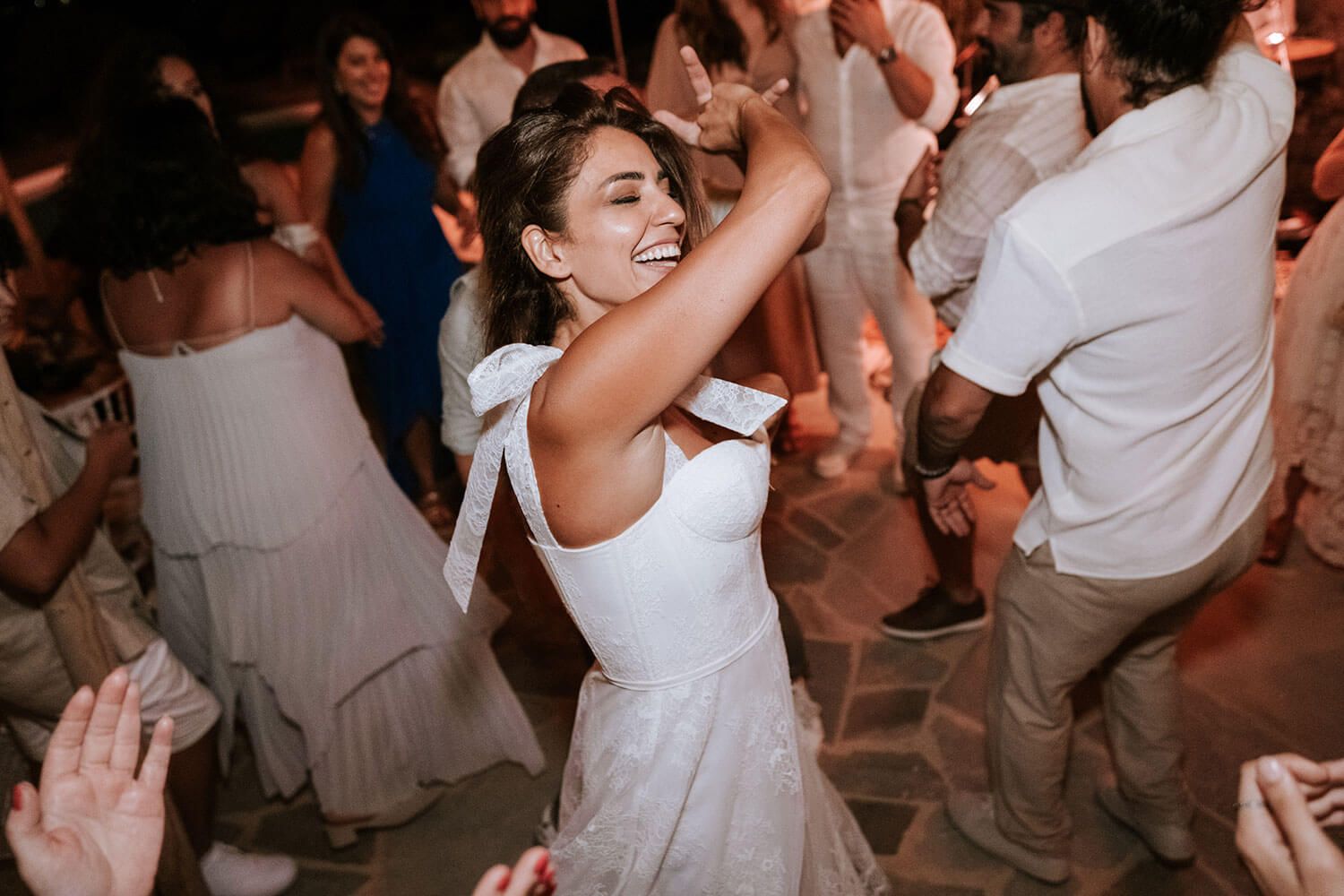 Bride Meli dancing enthusiastically with her friends in Paros