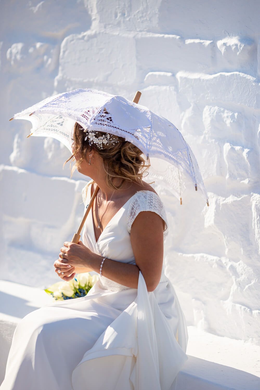 Bride holding un umbrella after her wedding at  Pyrgaki chapeli in Paros Greece