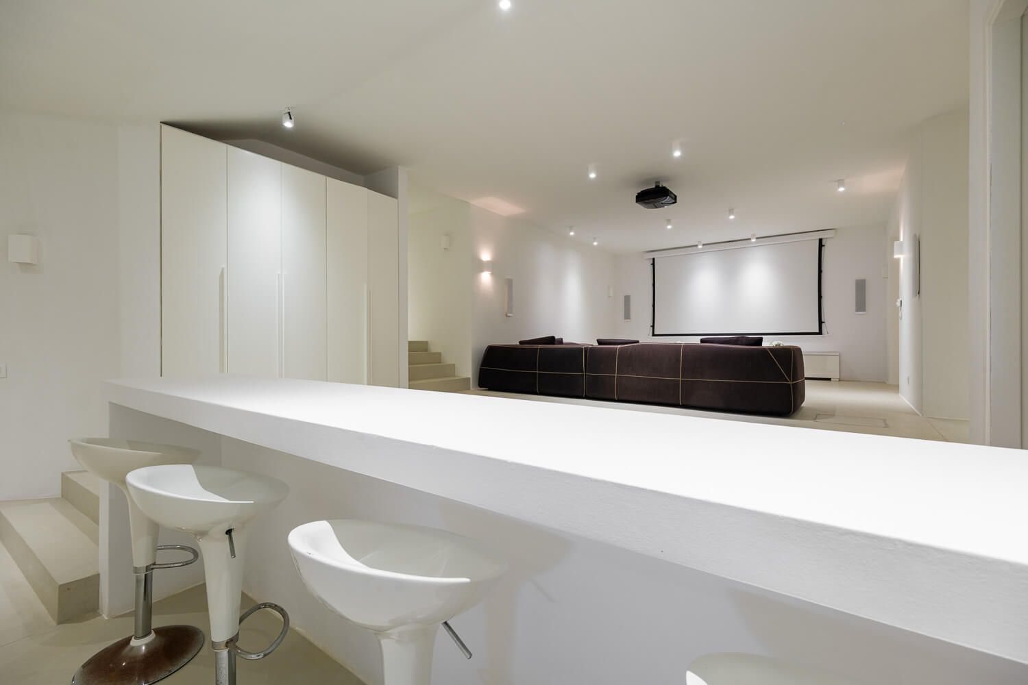 Modern white interior hallway with recessed lighting and sleek minimalist design features clean lines and bright surfaces.