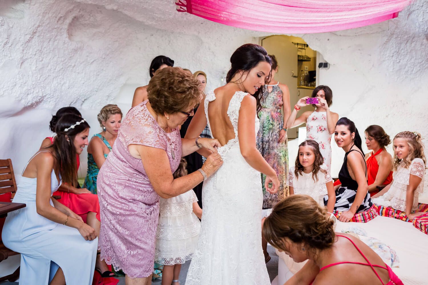 Bride putting on her wedding dress inside a restored cave house