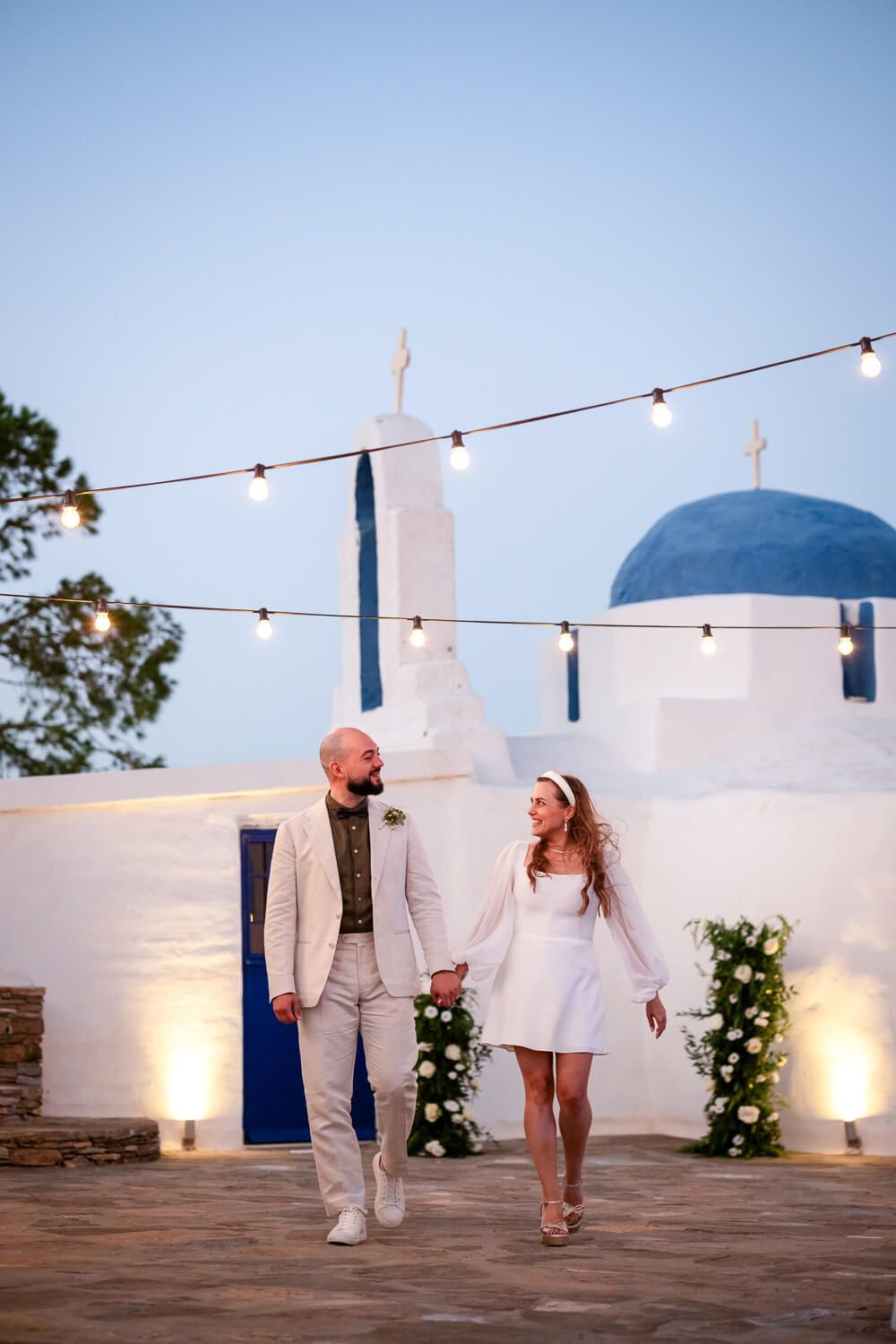 Bride and groom walking hand in hand at the Secret View Venue in Paros Island