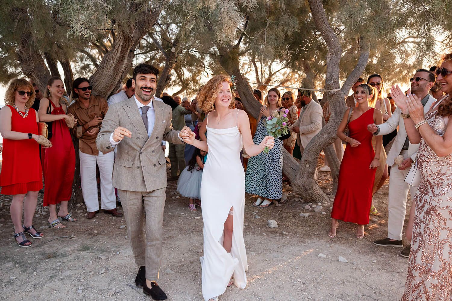 Joyful newlyweds walking back up the aisle at Thalassa Mou