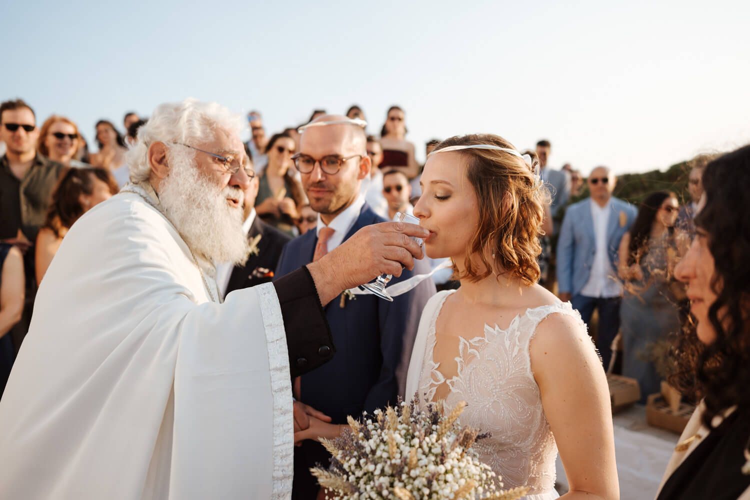 Authentic Greek wedding traditions,drinking wine, captured by a Paros photographer
