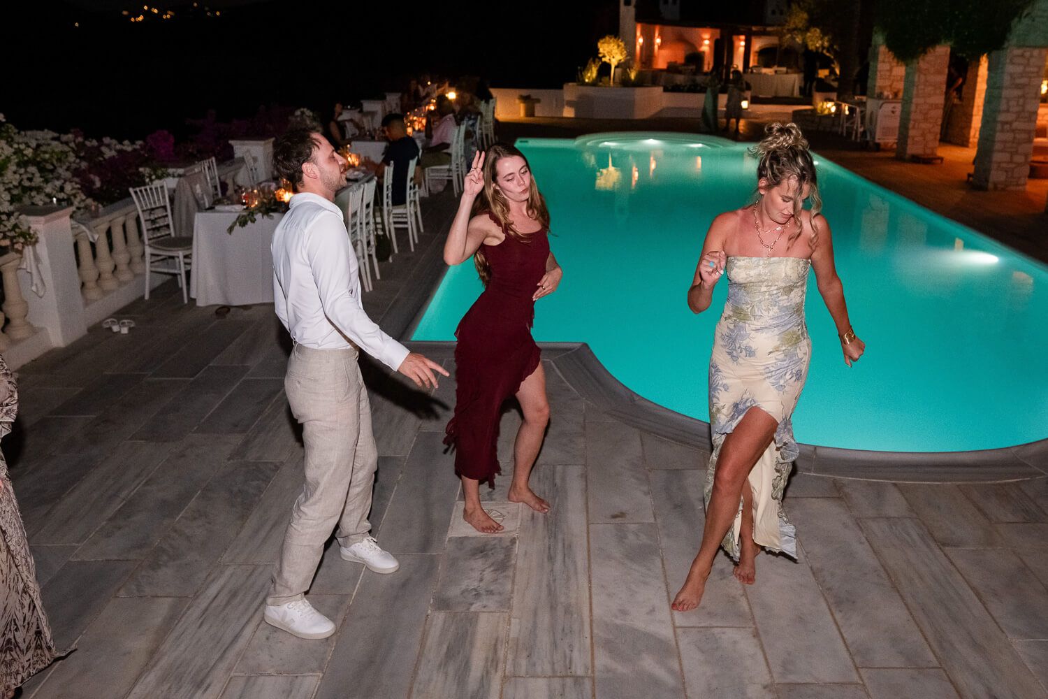 Guests dancing by the pool during a wedding reception in Paros Greece