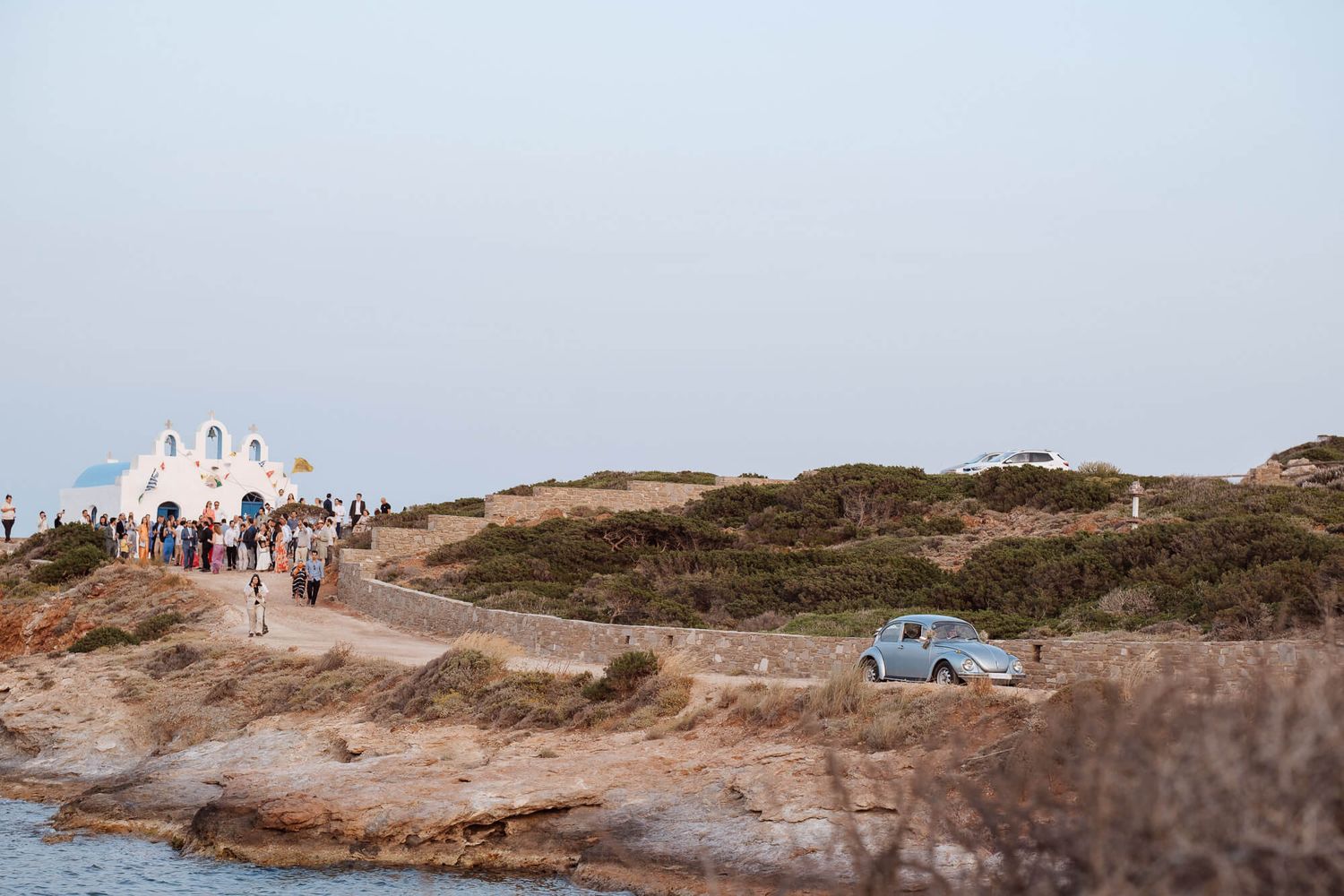 Vintage beetle Volkswagen with newlyweds leaving the wedding ceremony at Pyrgaki chapel in Paros.