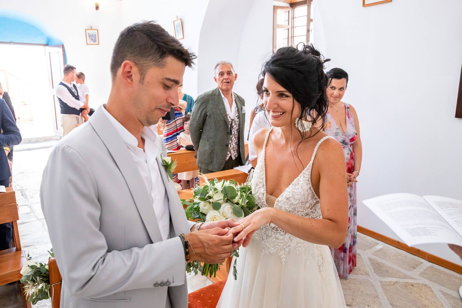 Couple exchanging rings during a Catholic wedding ceremony at St. Antony's church in Paros