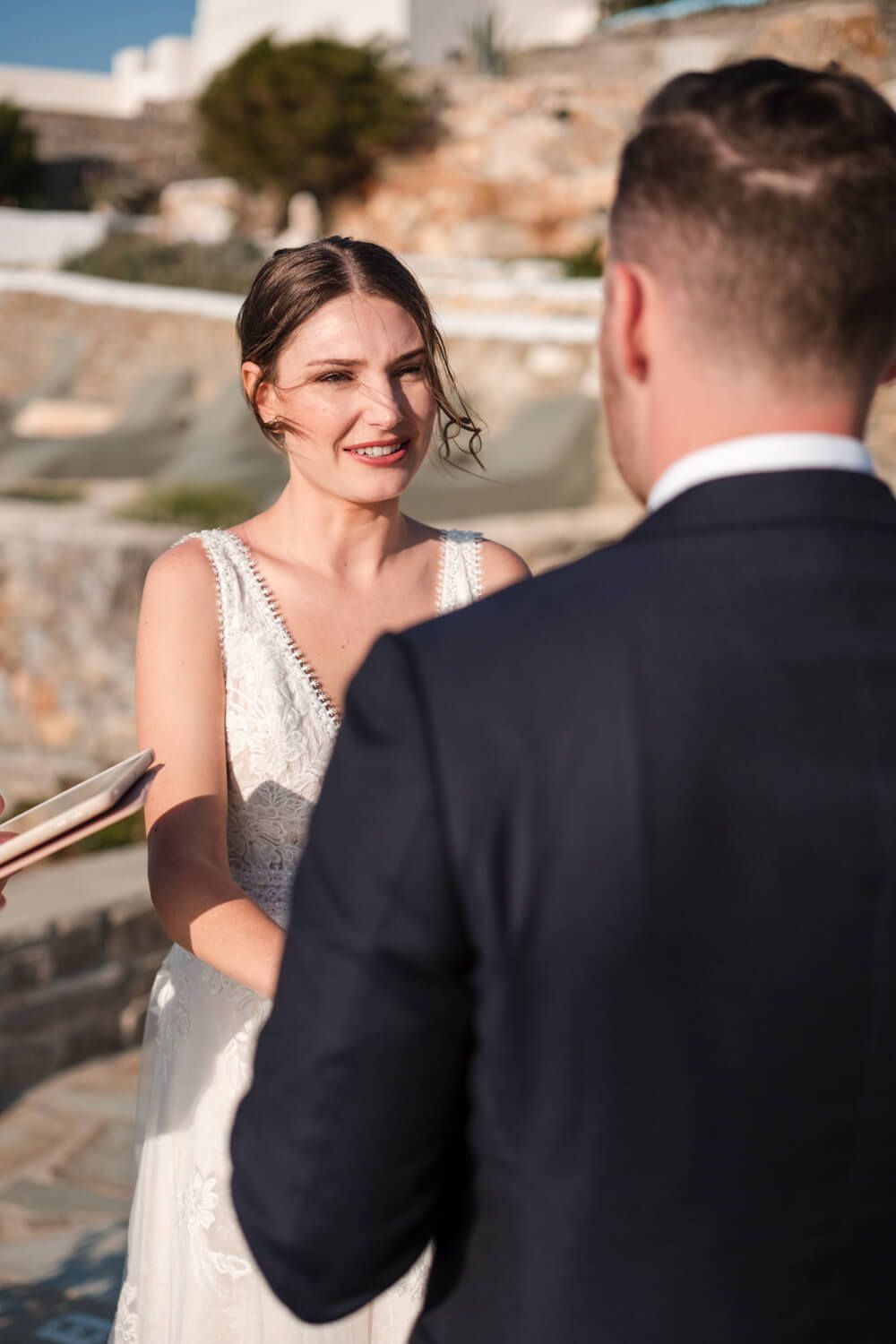 Lizzy and Cody exchanging vows with a stunning Aegean backdrop