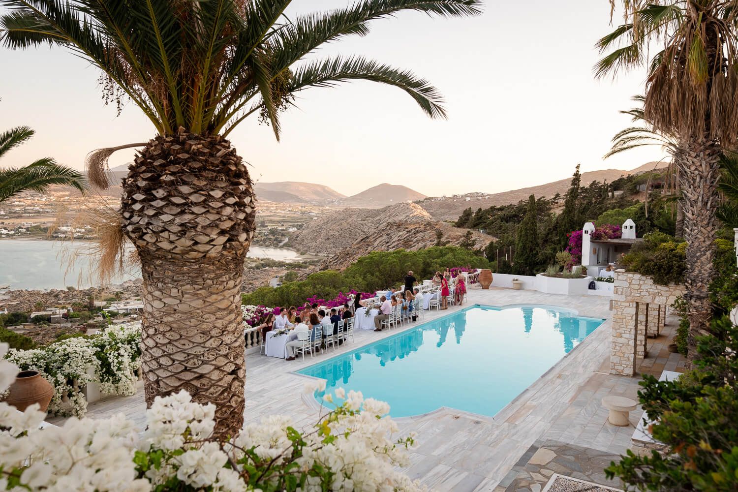 Elegant dinner tables set by the pool at Petra Farm Paros