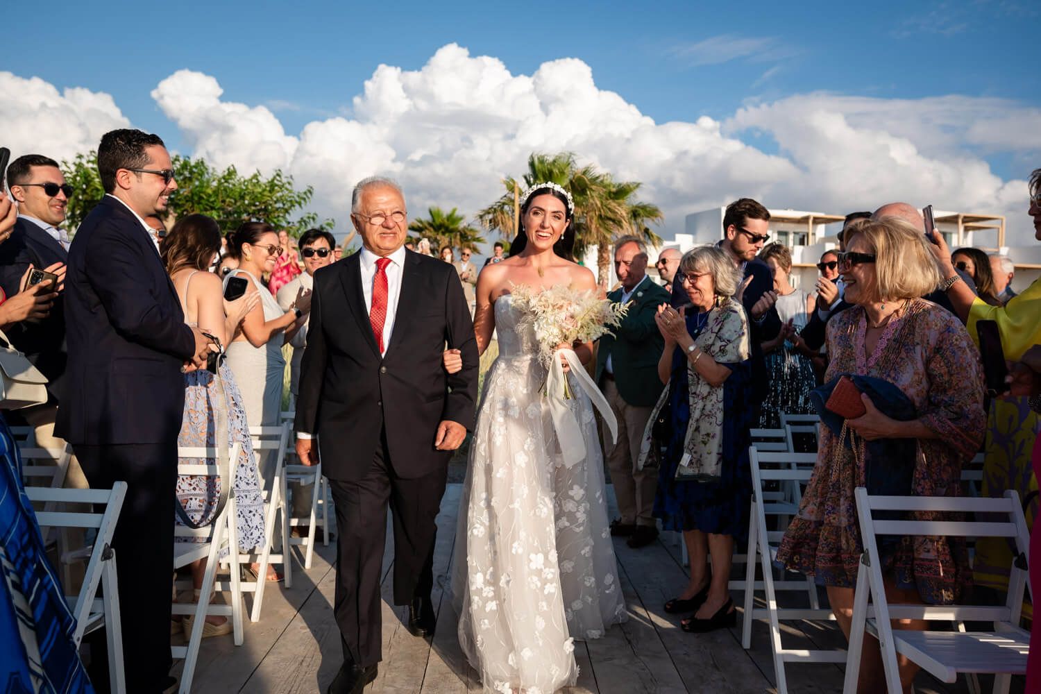 bride escorted by her father during a symbolic ceremony at Seesoo Paros Hotel