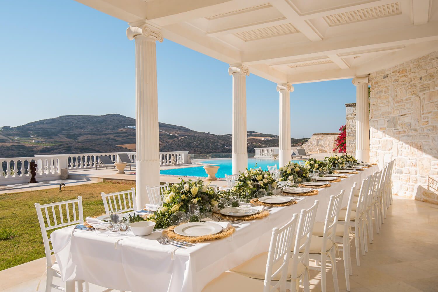 Formal wedding dinner tables decorated with white flowers and candles
