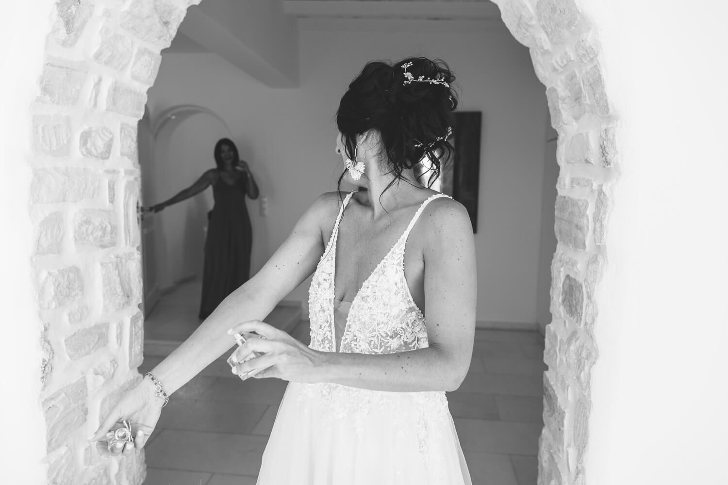 Bride smiling while her bridesmaids help her put on the wedding dress