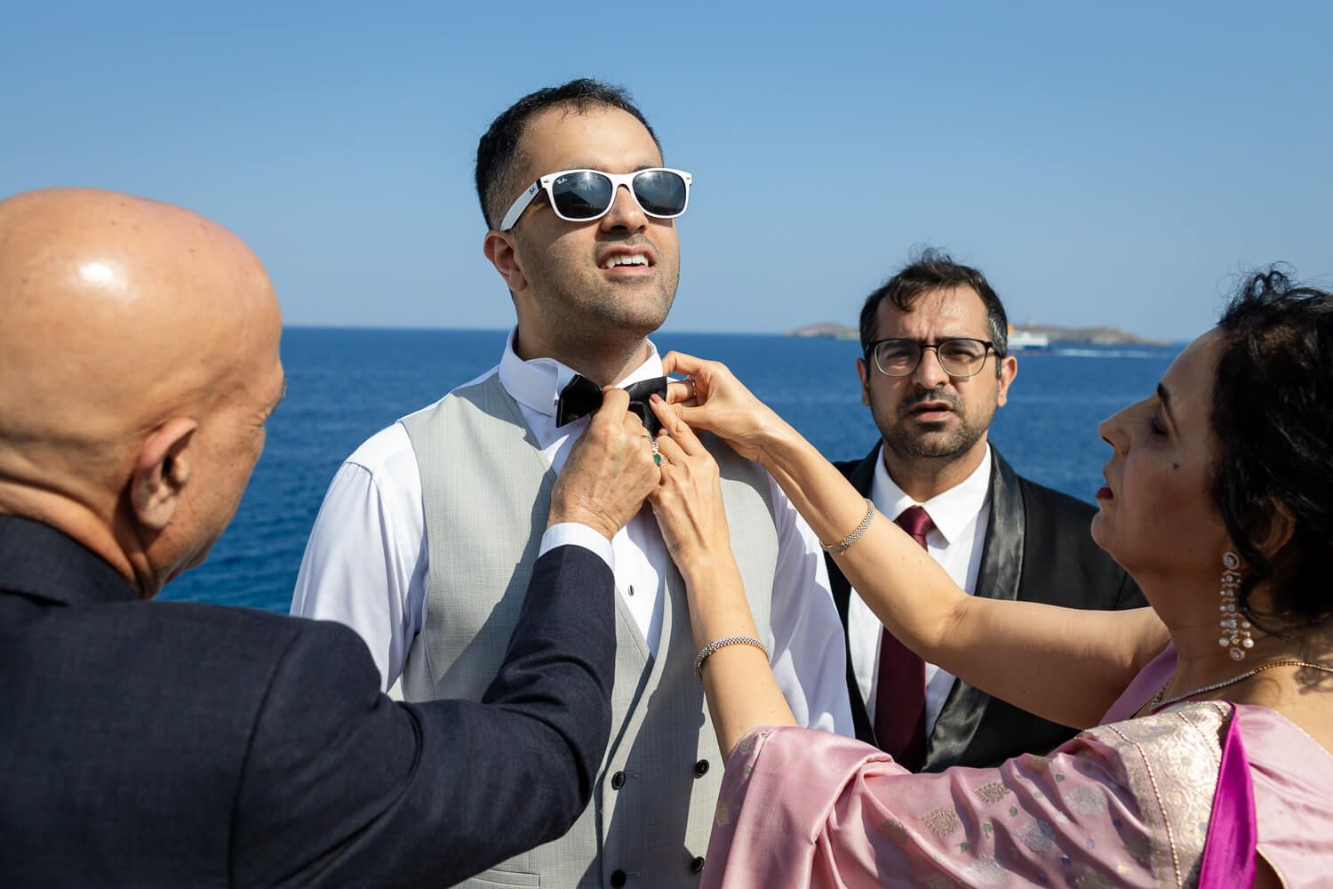 Groom tying his bowtie in a beautiful traditional Syros house