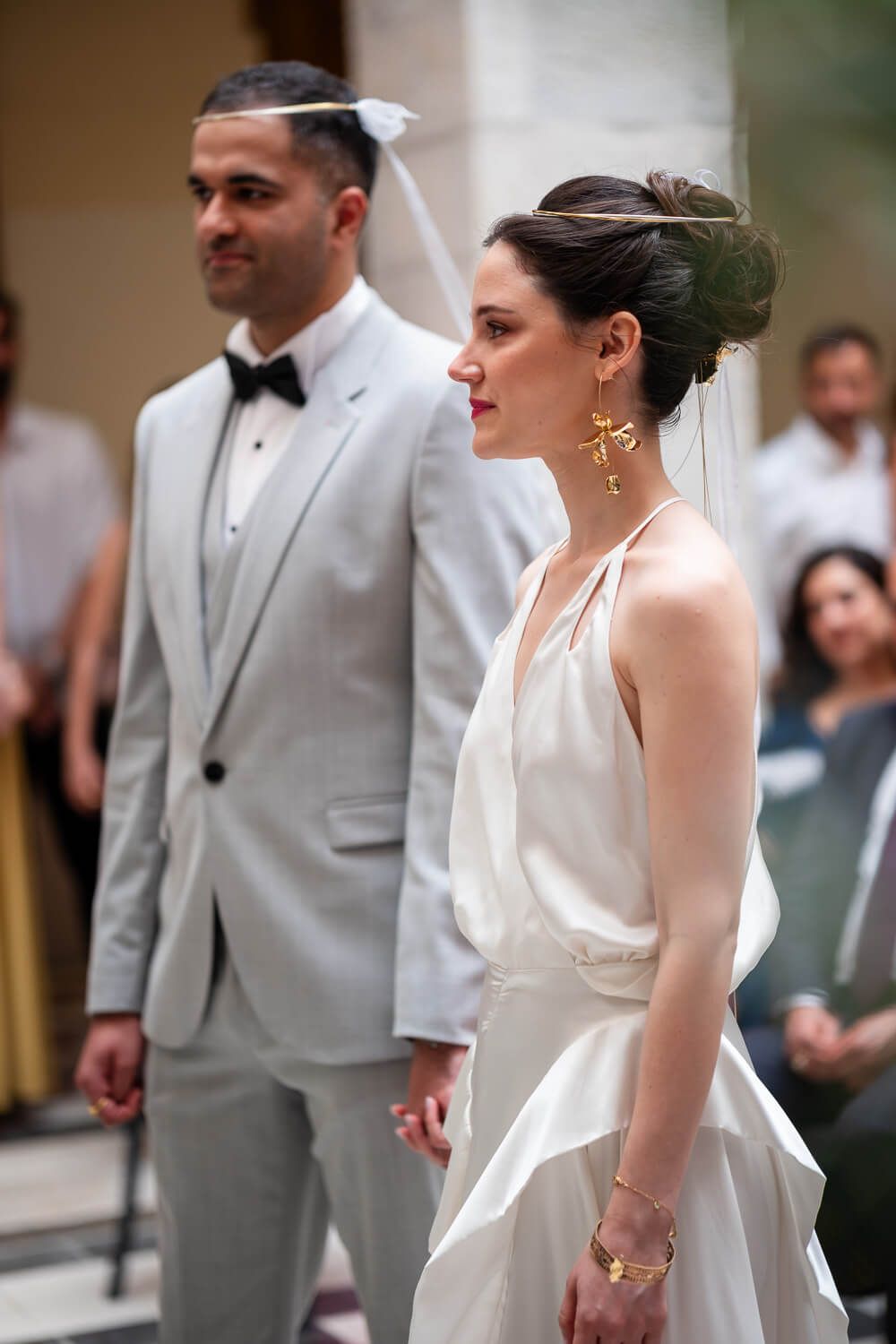The couple holding hands under the beautiful town hall arches