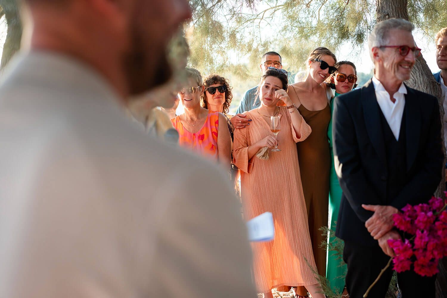 Wedding guests wiping happy tears during a seaside ceremony in Greece