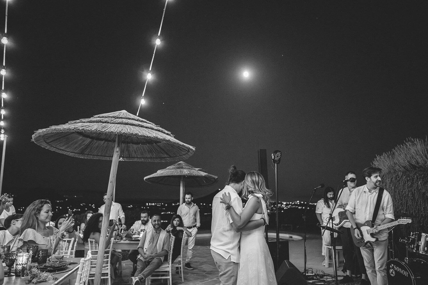 The couple sharing a romantic but fun first during their wedding reception in Paros island