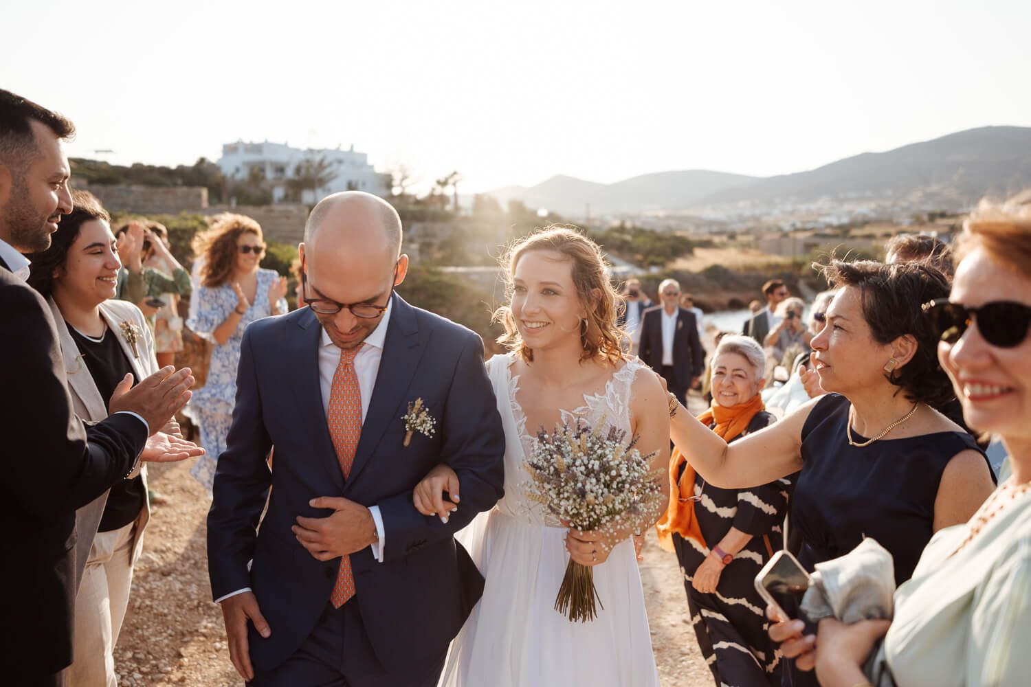 Bride and groom walking towards the church before their Paros wedding