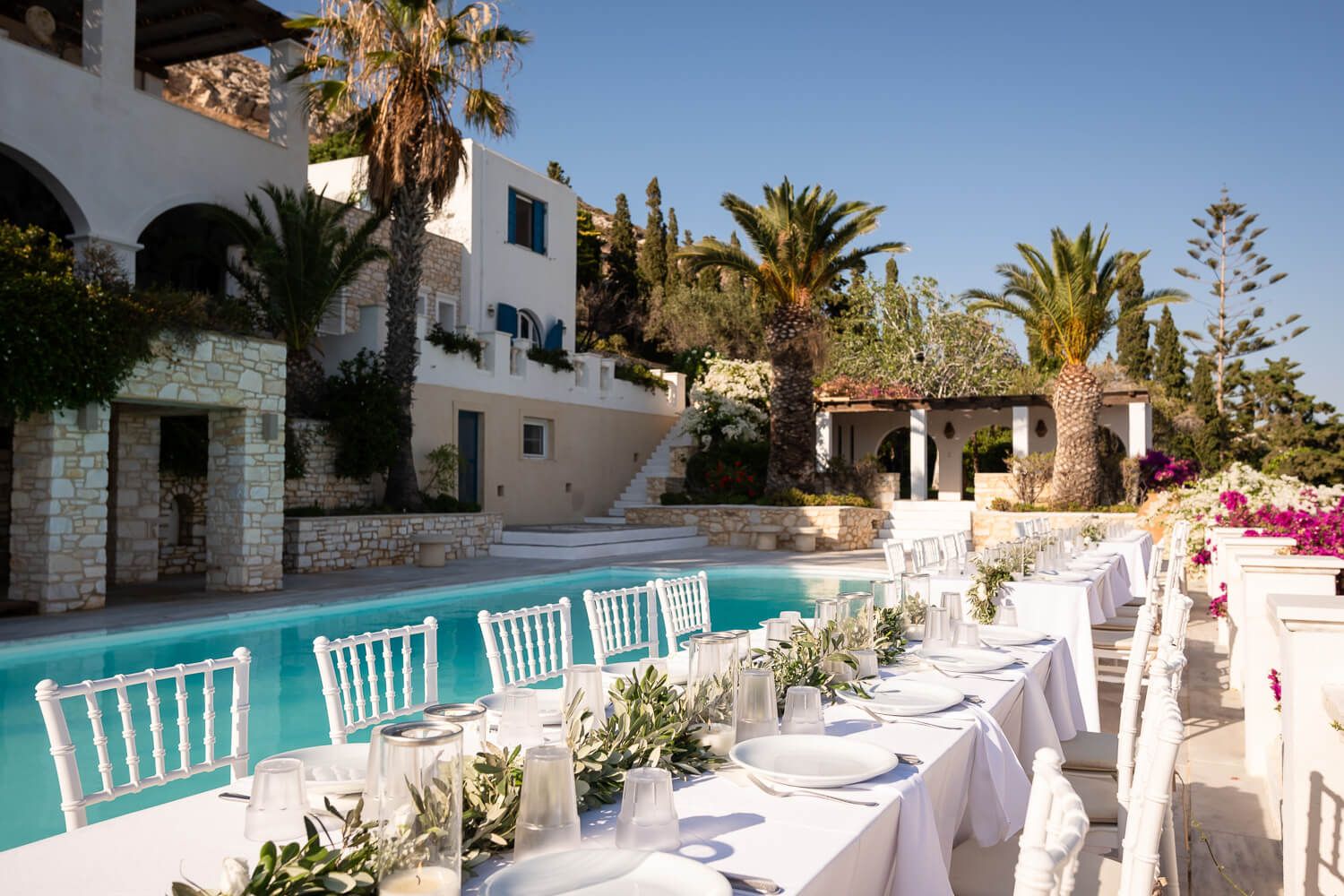 Elegant dinner tables set by the pool at Petra Farm Paros