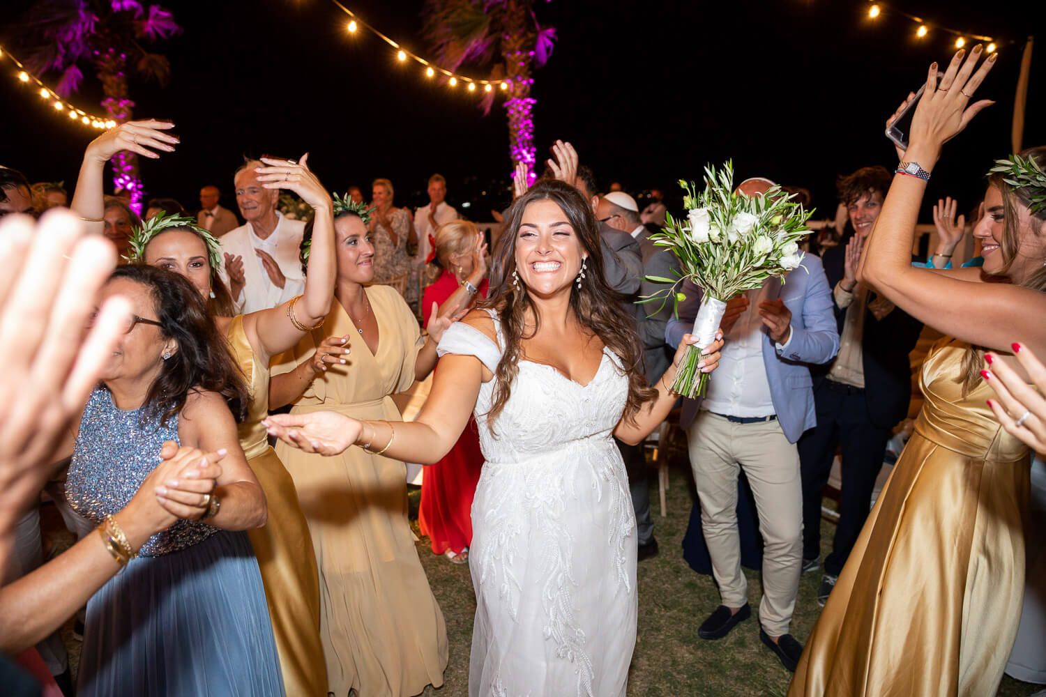 bride looking at the camera during a Jewish wedding party at night under the stars in Villa Aethra
