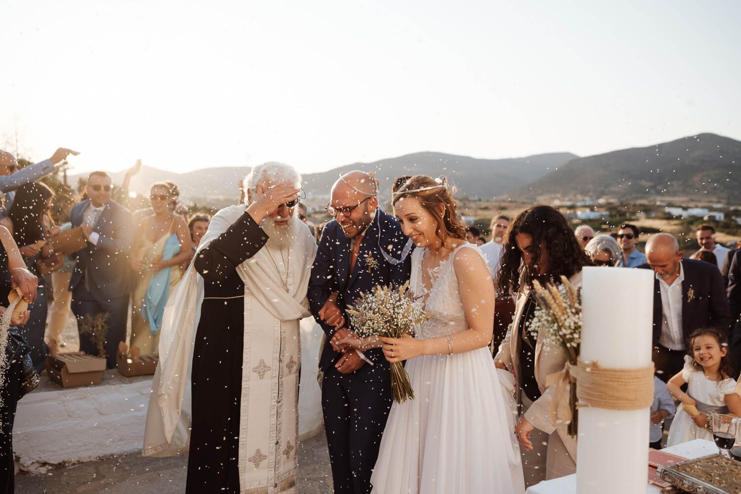 Guests throwing rice to celebrate Dimitris and Ioanna