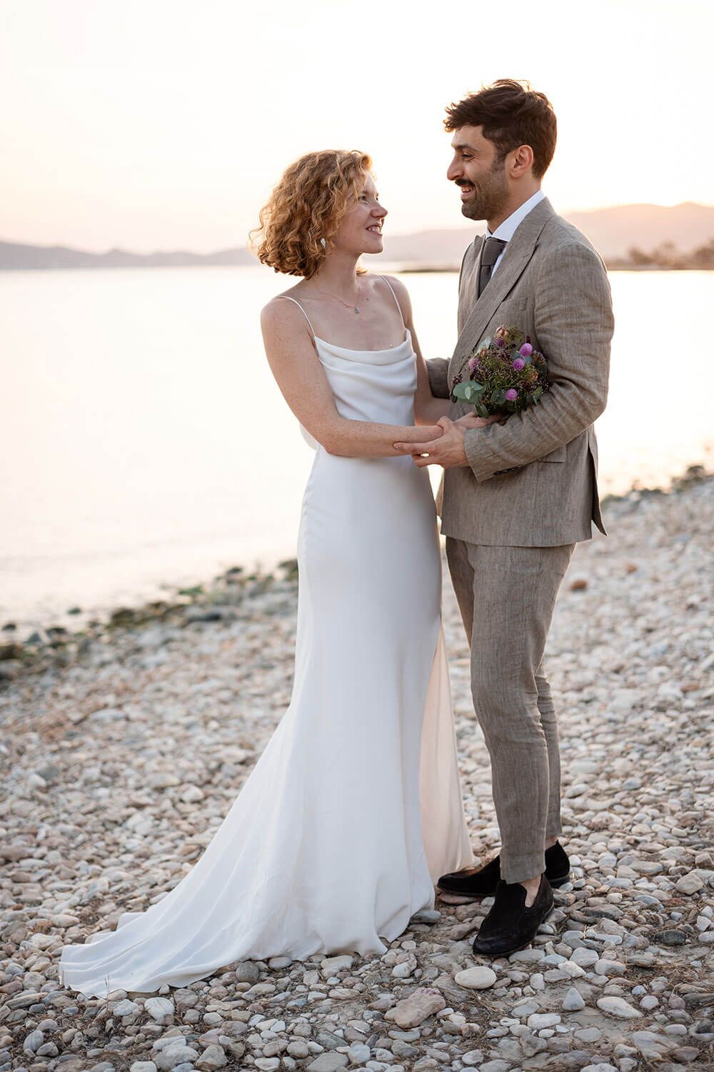 Bride and groom embracing with a beautiful Cycladic sunset behind them