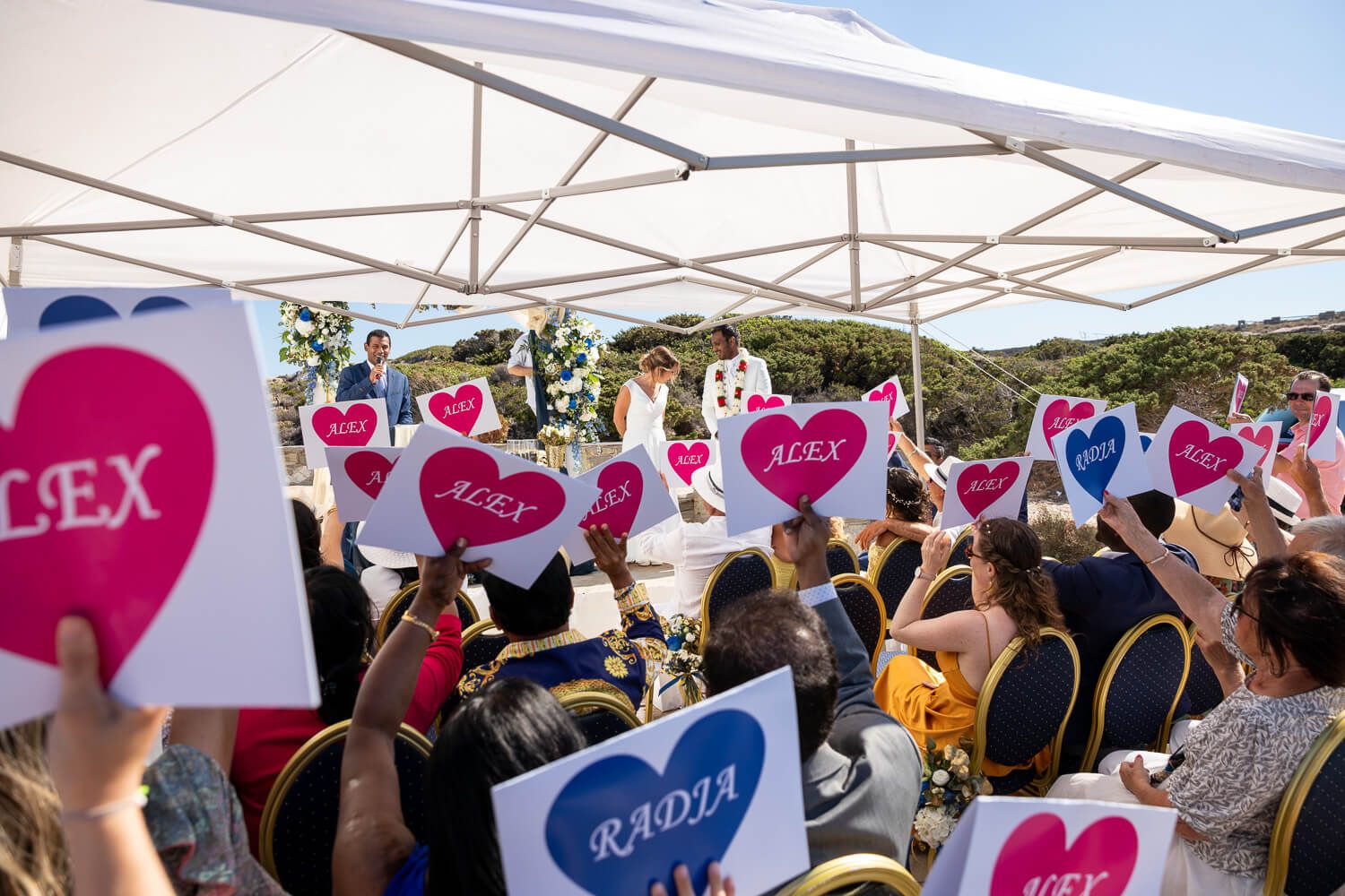 Guests throwing petals at the smiling couple after their symbolic ceremony