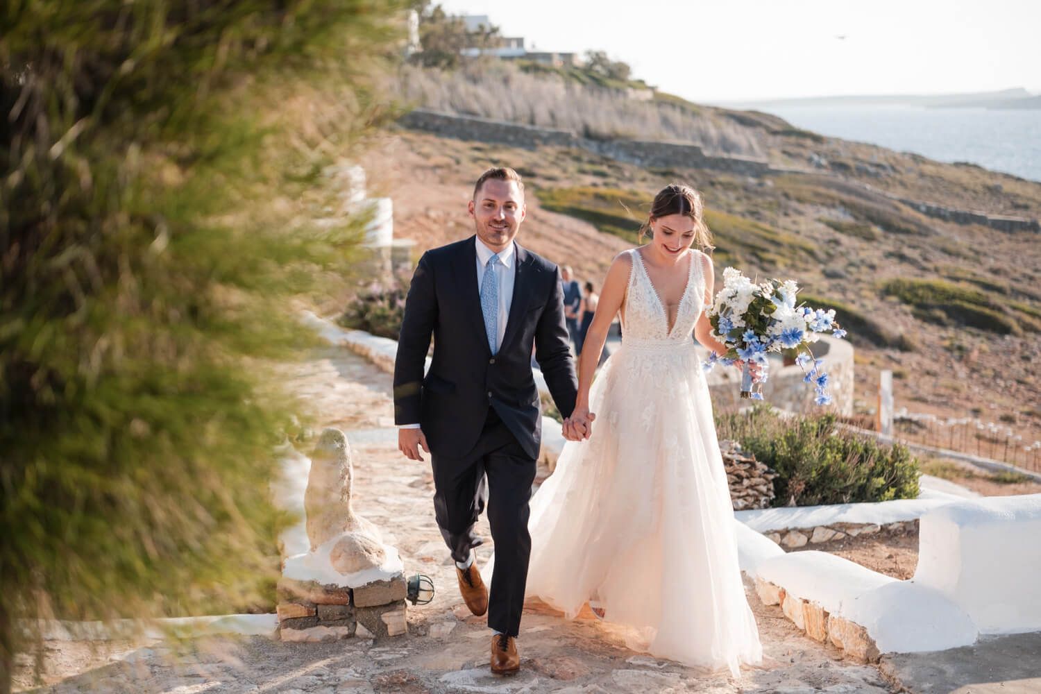 The newlyweds walking hand in hand around Villa Lady of Paros