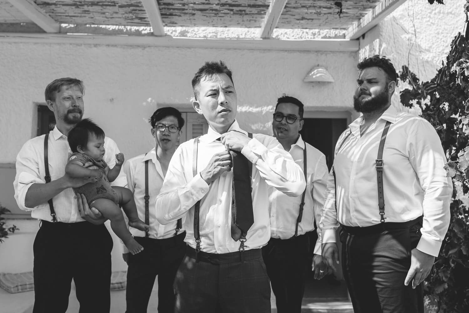 Putting on the groom's jacket - Black and white detail