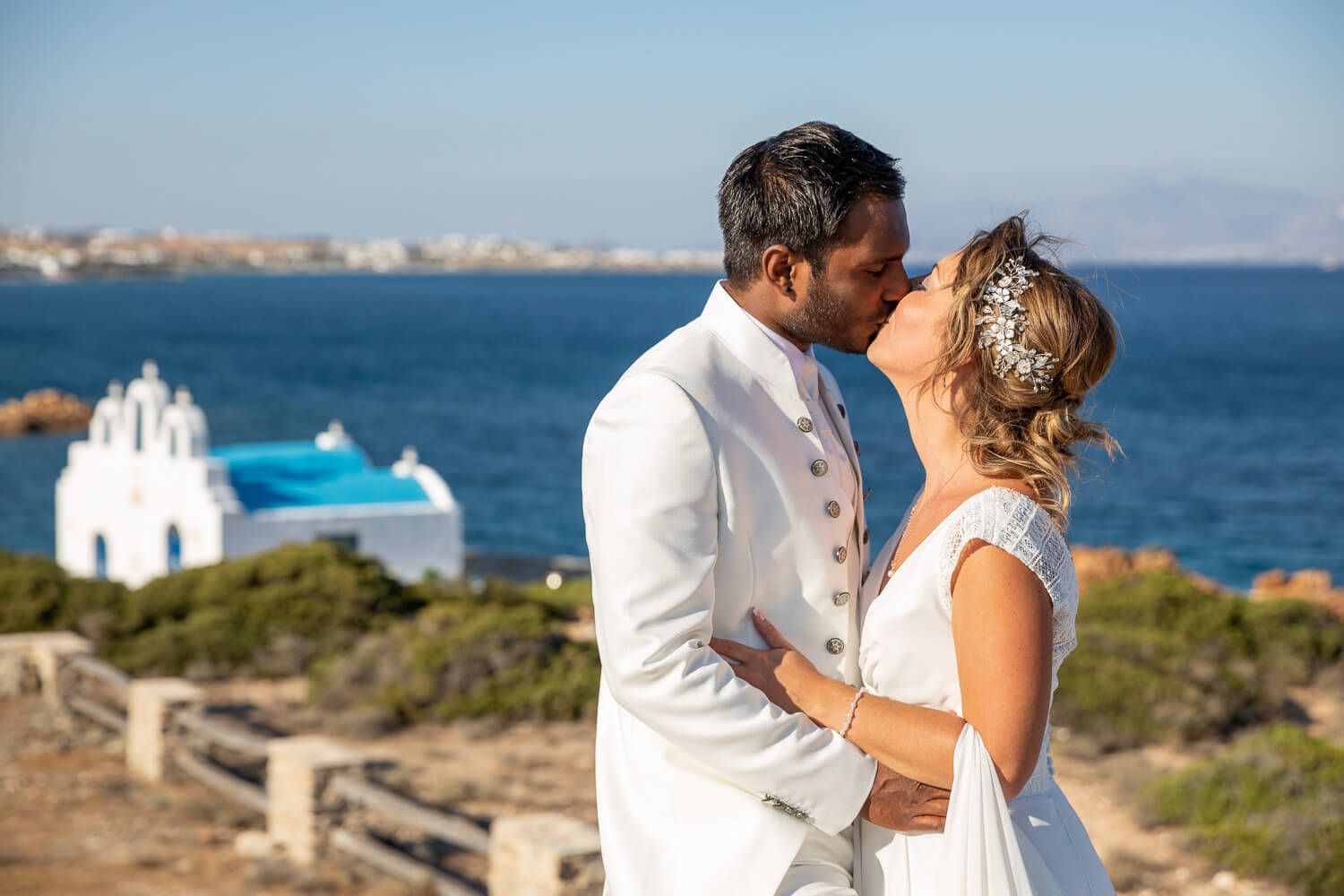 Newlyweds walking hand in hand at Pyrgaki chapeli in Paros Greece