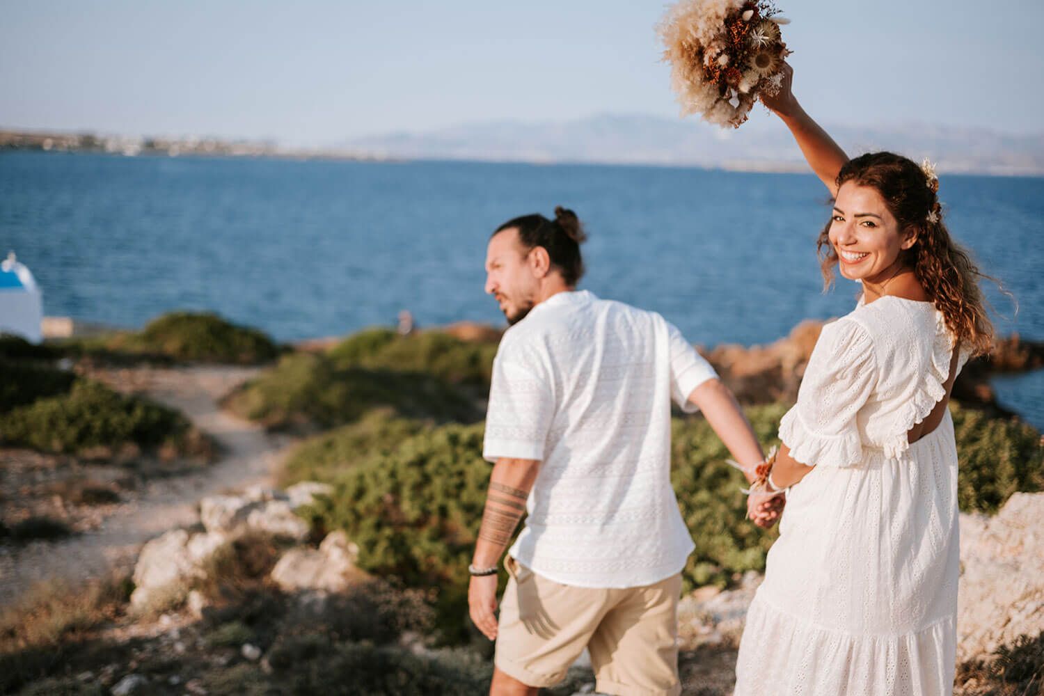Meli and Rady exploring the wild Cycladic landscape during their engagement session