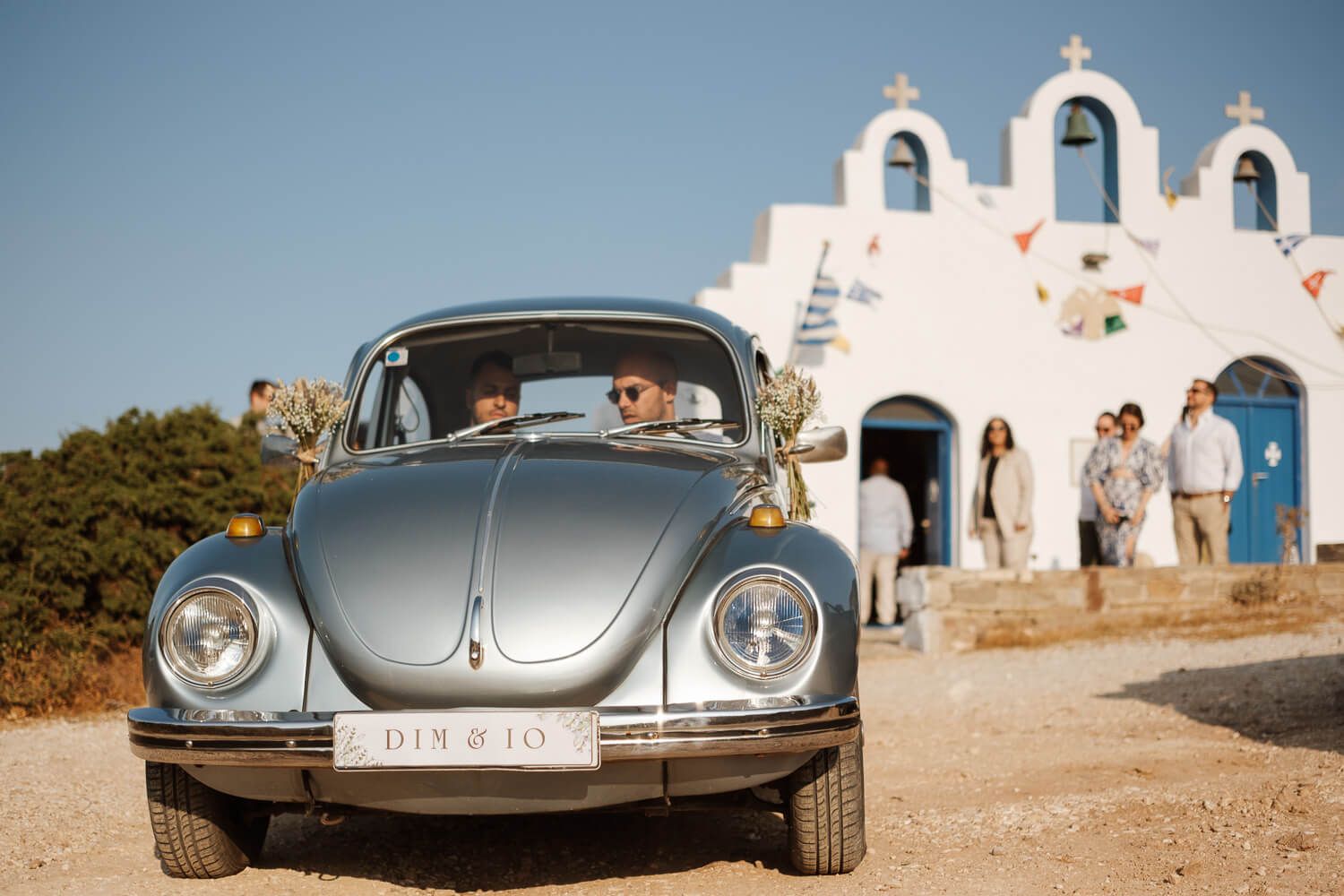 Groom Dimitris with his best man arriving at Pyrgaki chapel in a vintage VW Beetle