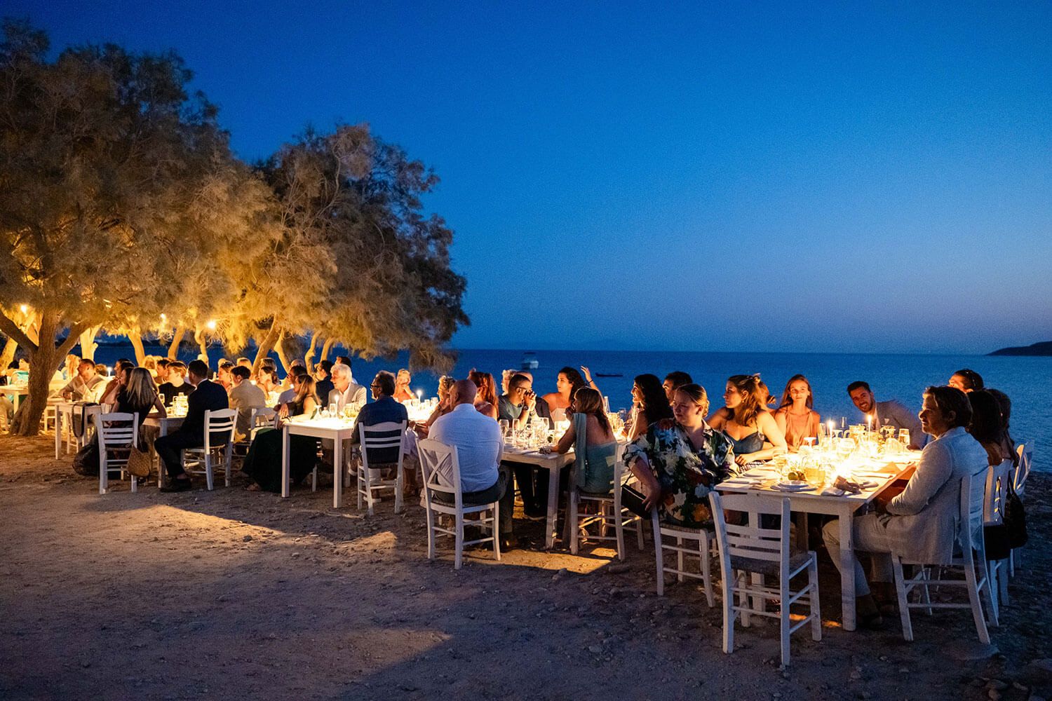 Elegant wedding dinner tables set directly on the sand at Thalassa Mou