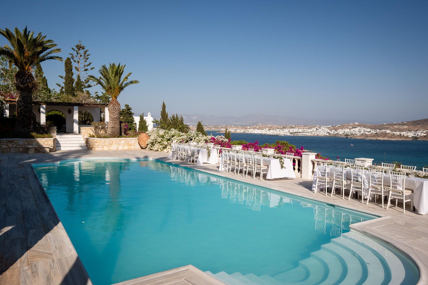 Luxury infinity pool overlooking Naousa Paros against blue skies.