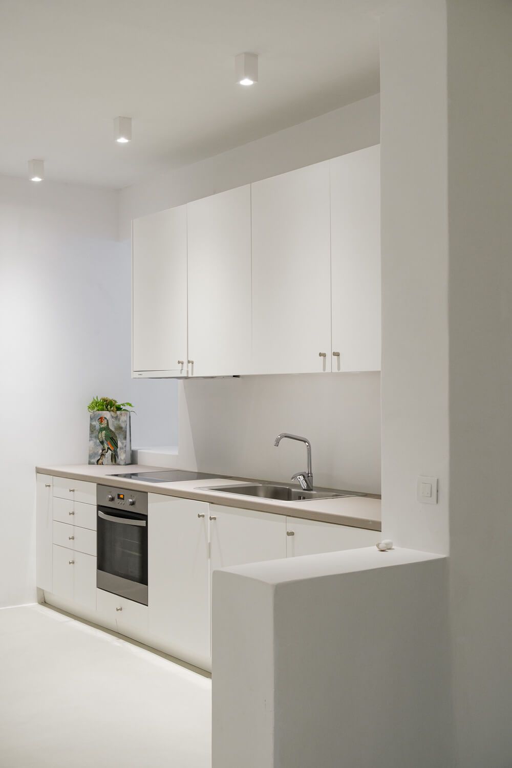 Modern white kitchen with minimalist design featuring sleek cabinets, built-in appliances and quartz countertops.