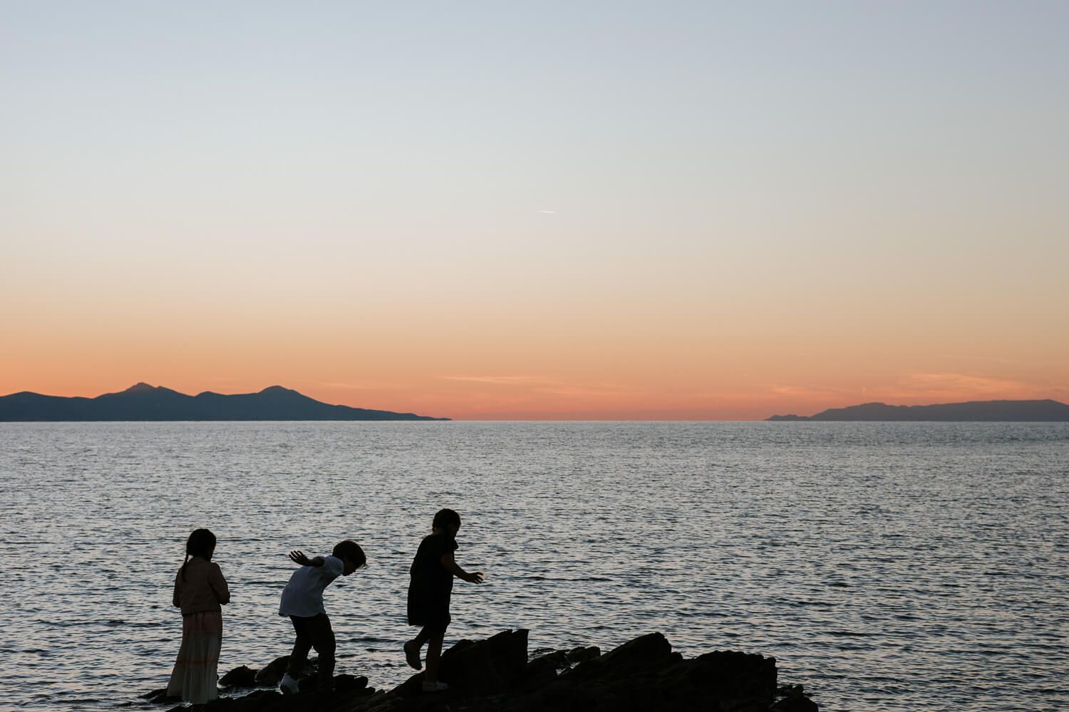 Παιδιά παίζουν πάνω στα βράχια  μετά από βάπτιση στον Άγιο Γεώργιο της Αντιπάρου.