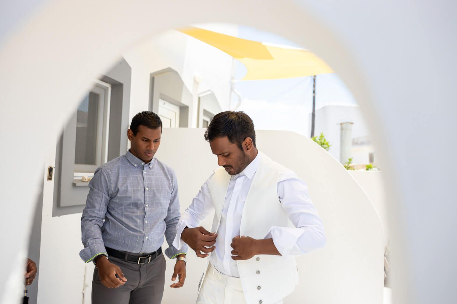 Groom sharing a laugh with friends during wedding prep in the Cyclades