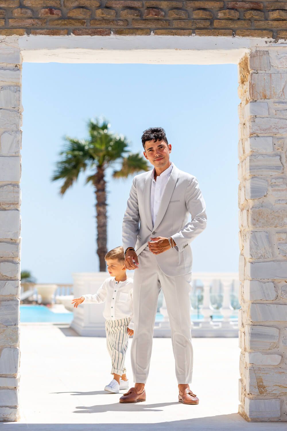 Groom Marco posing with his son before his destination wedding in Paros Greece