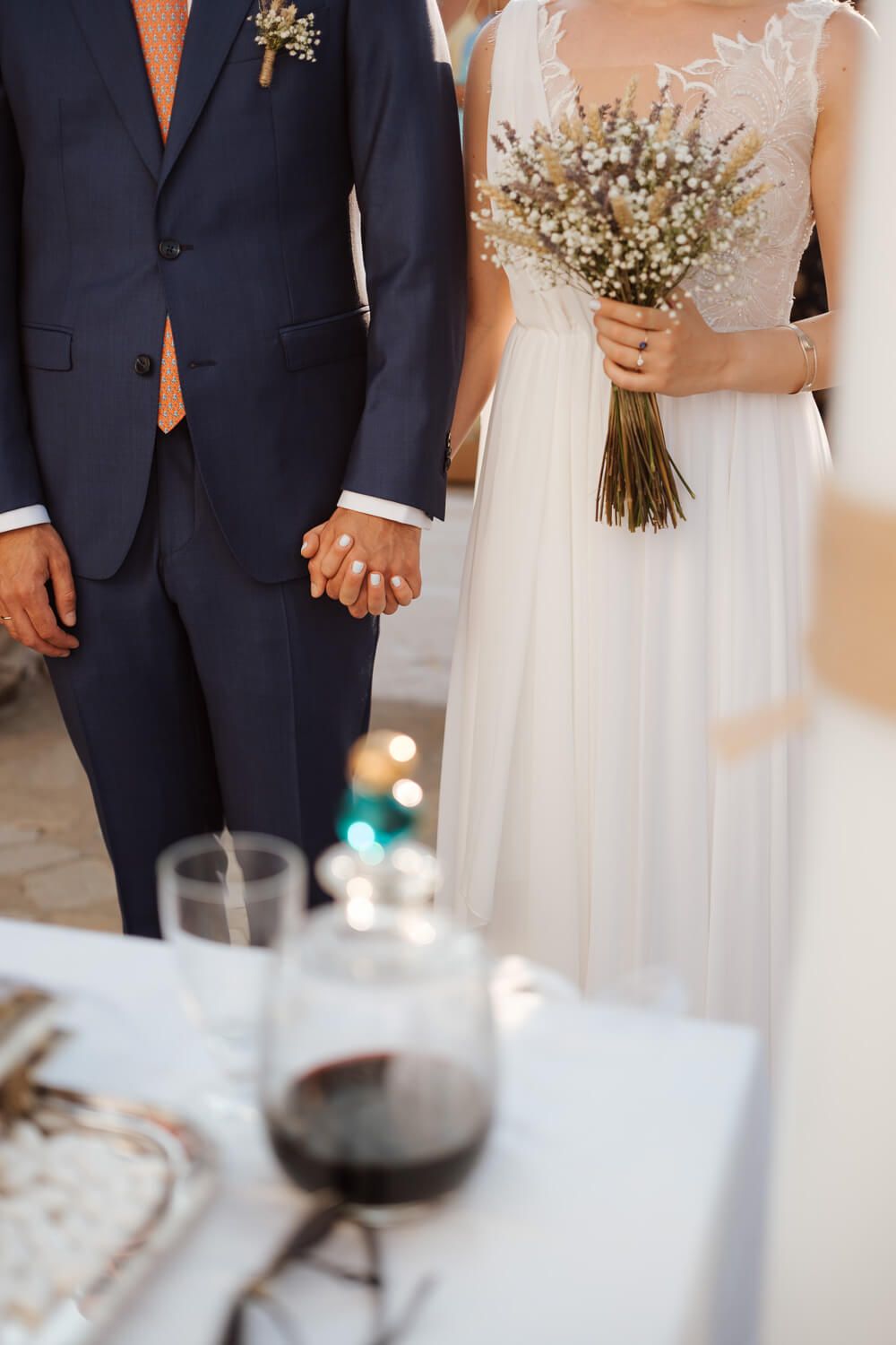 Close up of groom and bride holding hands during an Orthodox ceremony