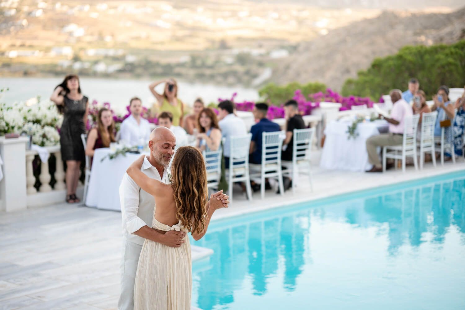 The couple sharing a romantic first dance by the pool in Paros