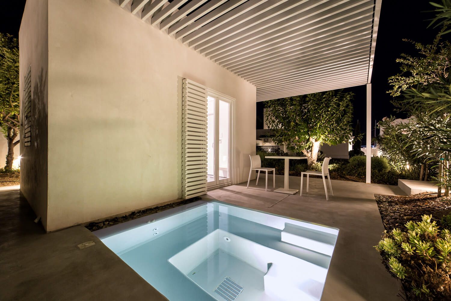 Illuminated private jacuzzis offering a relaxing nighttime experience at Ios