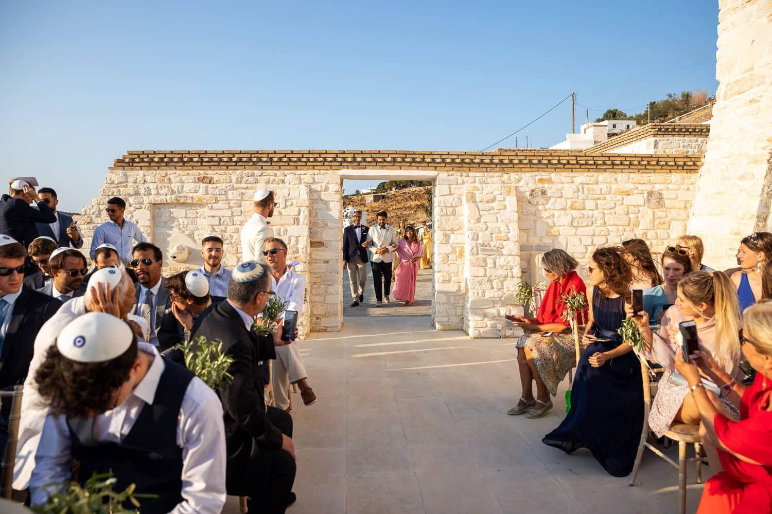 Groom entering ceremony area during a Jewish wedding in Paros