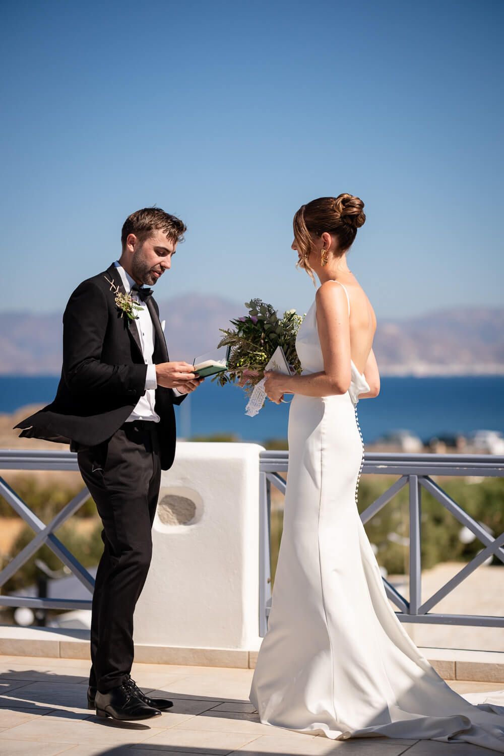 Emotional vow rehearsal on a villa rooftop overlooking the Aegean Sea